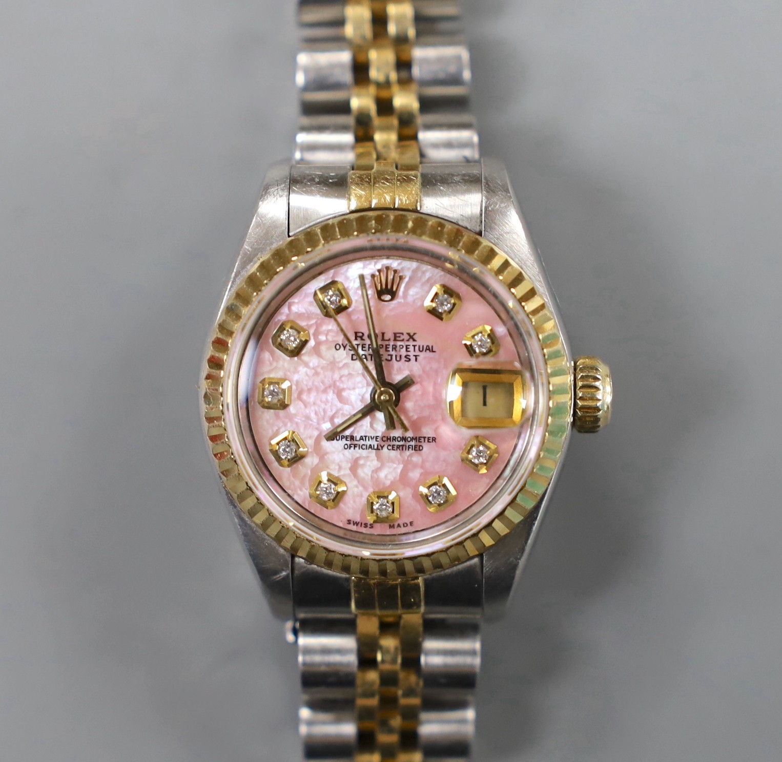 A lady's 2015 steel and gold Rolex Oyster Perpetual Datejust wrist watch, with pink mother of pearl dial and diamond set markers, model no. 69173, serial no. R401799, case diameter 26mm, with box and certificate.
